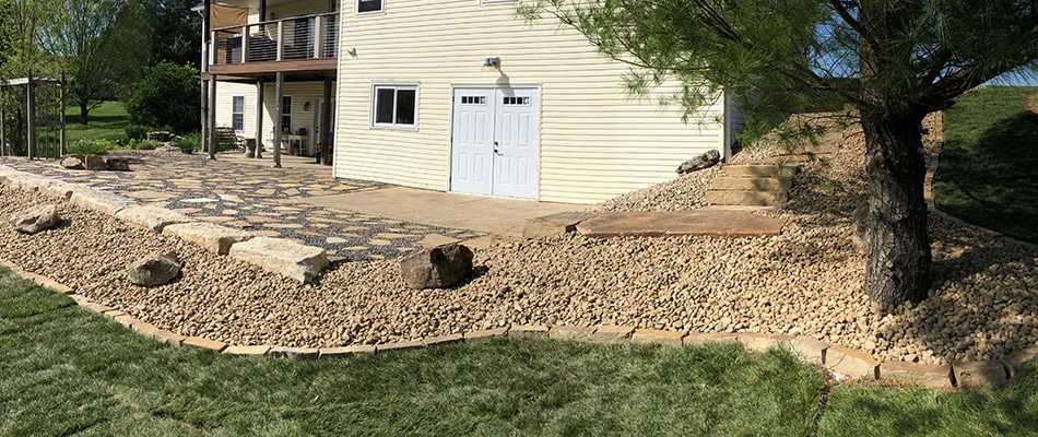 Landscape beds topped with rock mulch surrounding a brand new raised patio.