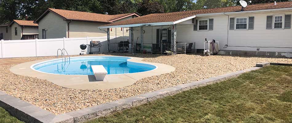 River rock installed around pool and new patio near Maryville, IL.