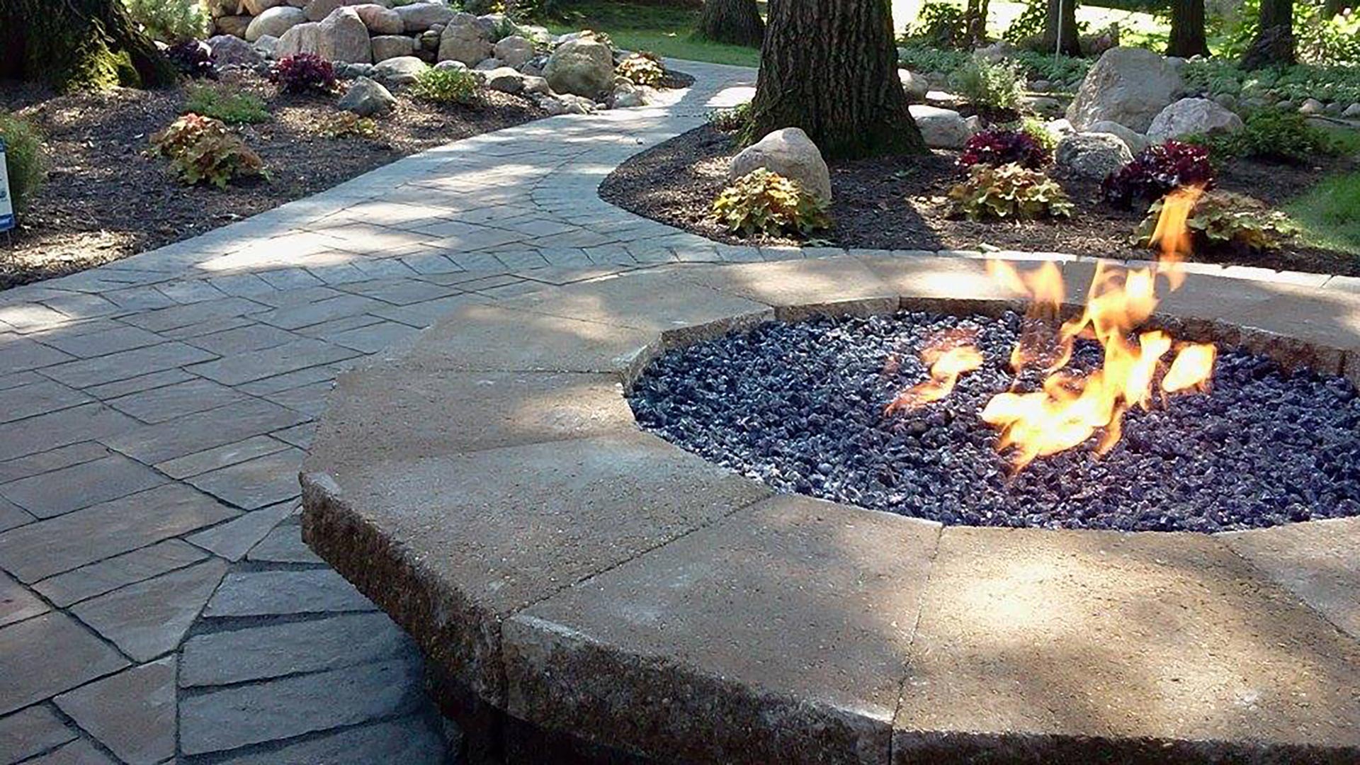 Outdoor firepit on a patio with surrounding landscape beds in Meadowbrook, IL.