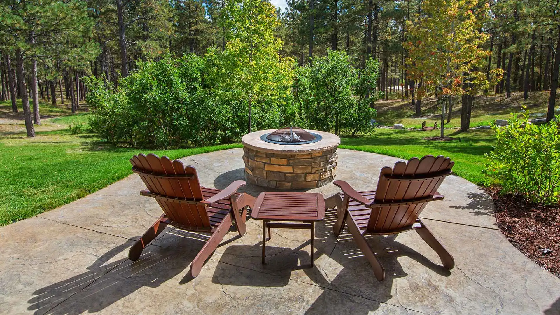 Outdoor living space with a custom fire pit and seating area in Edwardsville, IL.