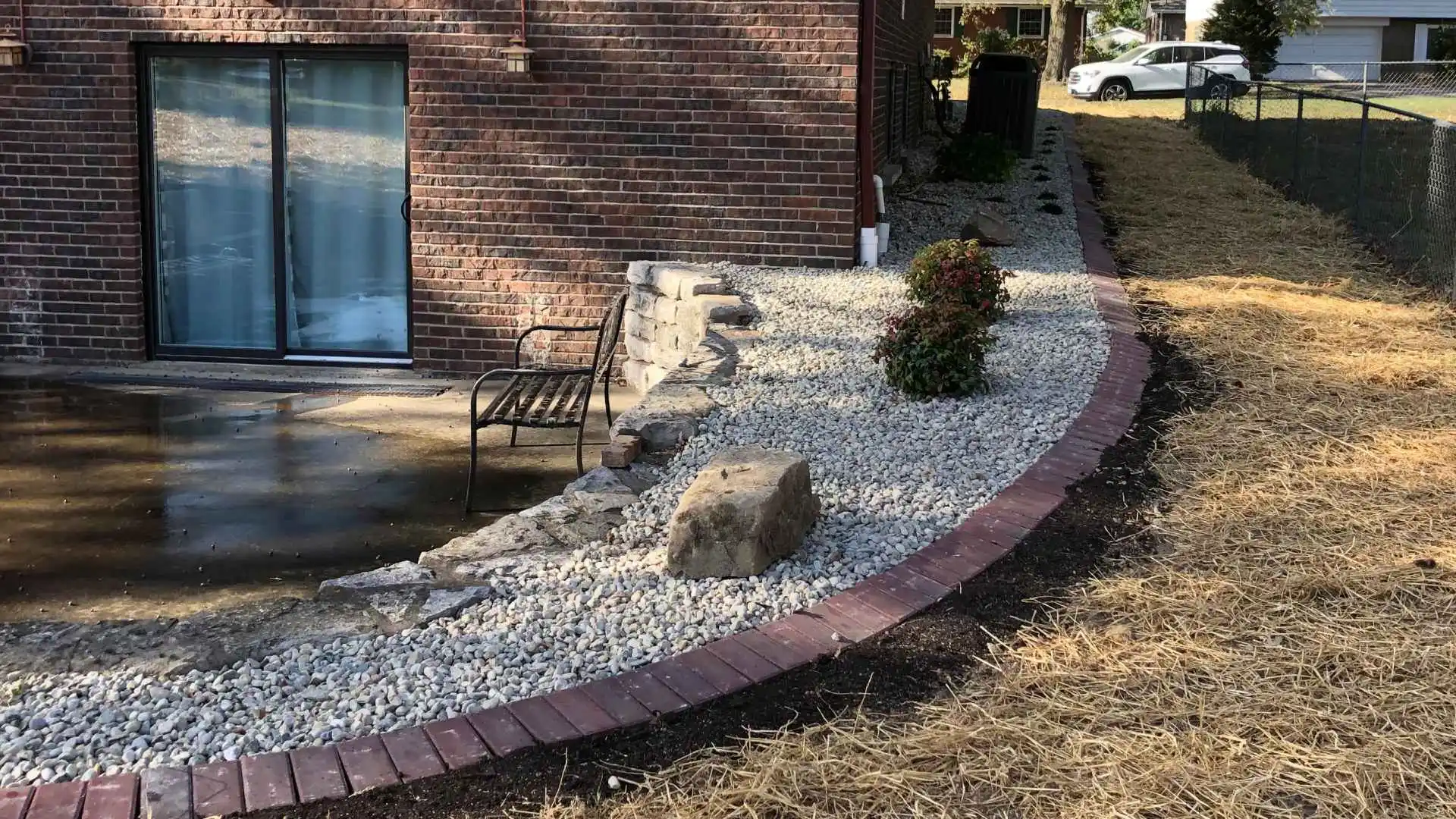 Retaining wall and landscape bed installed for sloped property in Greenville, IL.