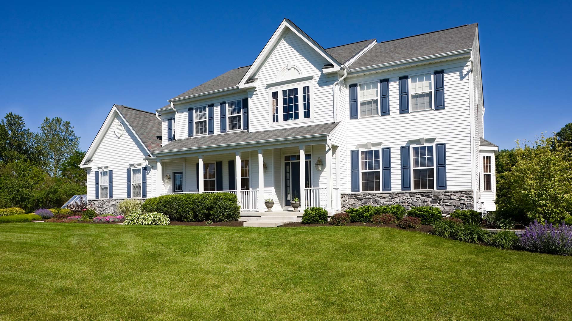 A white home with a healthy lawn and landscaping in Glen Carbon, IL.