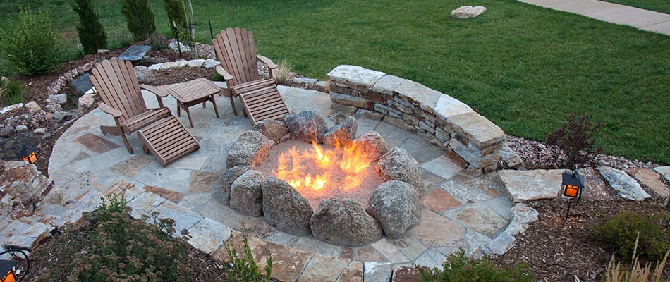 Custom boulder fire pit and seating wall built in Glen Carbon, IL.