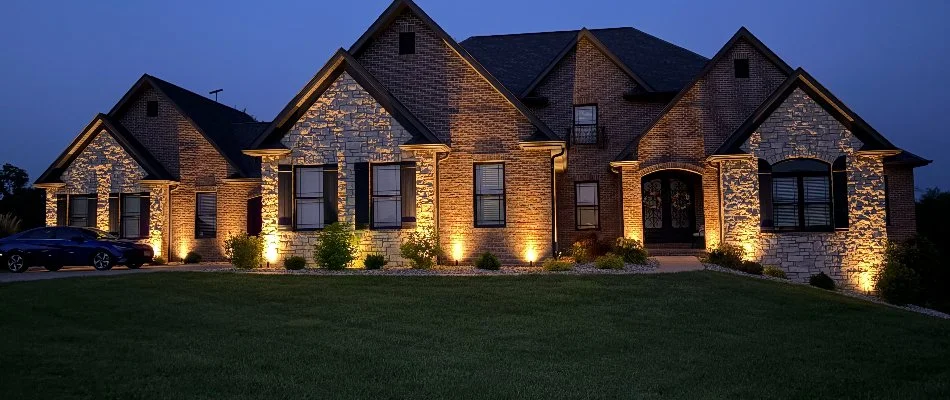 House in Edwardsville, IL, with warm landscape lighting.