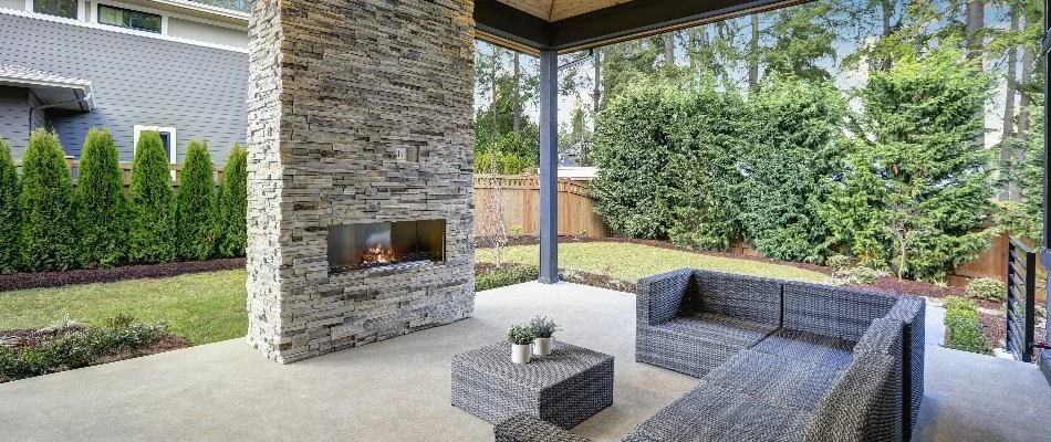 Large outdoor fireplace and seating on a concrete patio in Edwardsville, IL.