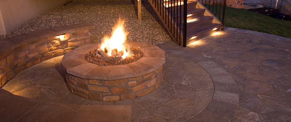 Natural stone fire pit and seating wall on a patio in Maryville, IL.