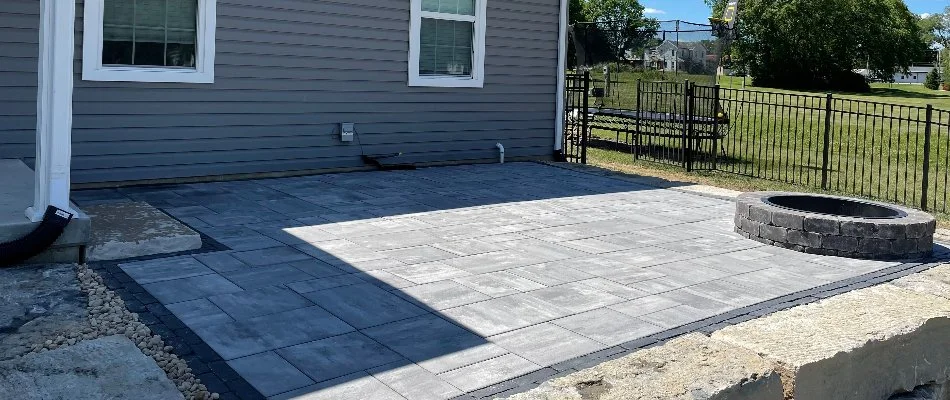 Paver patio along a house in Edwardsville, IL, with a fire pit.
