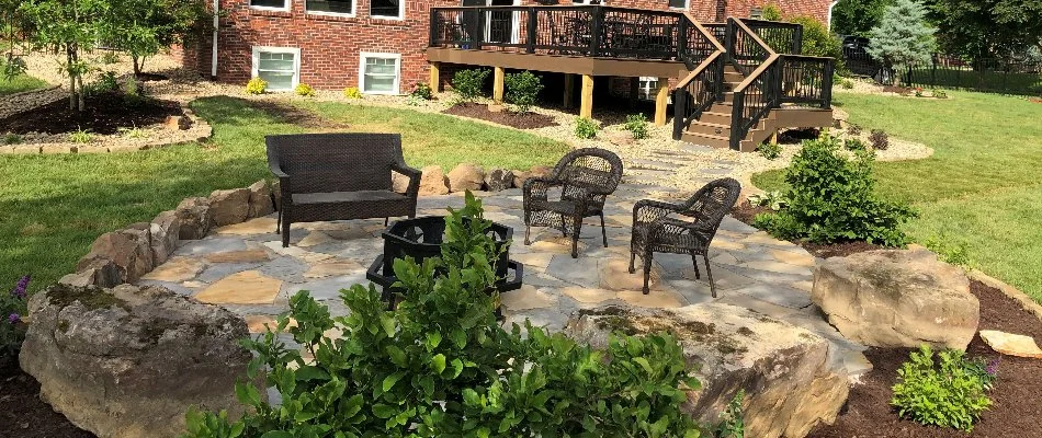 Plants around a patio in Edwardsville, IL, with outdoor furniture.