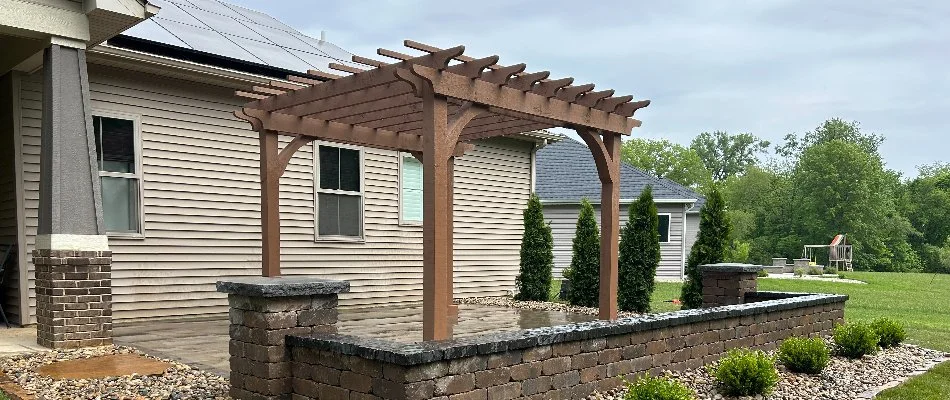 Small wood pergola and a seating wall on a patio in Edwardsville, IL.