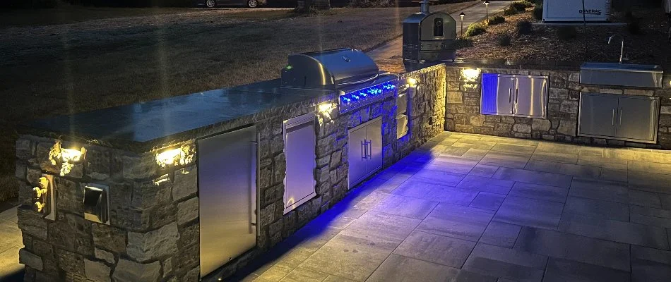 Stone outdoor kitchen in Edwardsville, IL, with lighting.