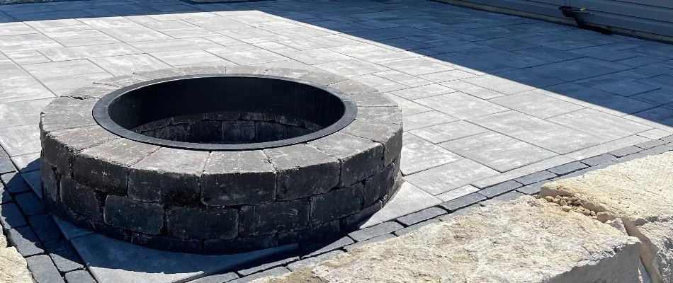 Wood-burning fire pit in Edwardsville, IL, on a paver patio.