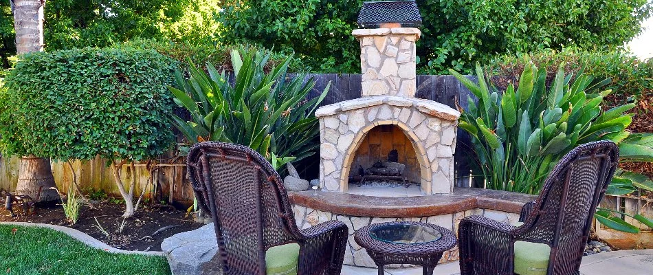 Outdoor fireplace with two chairs in front on a property in Edwardsville, IL.