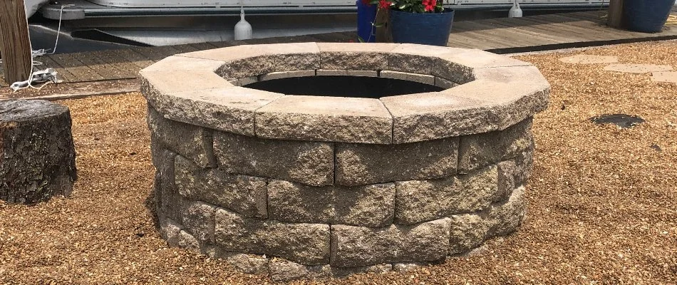 Block fire pit in brown gravel in Edwardsville, IL.