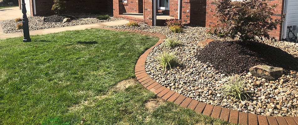 Refreshed landscape bed with brick edging and rock ground cover in Meadowbrook, IL.