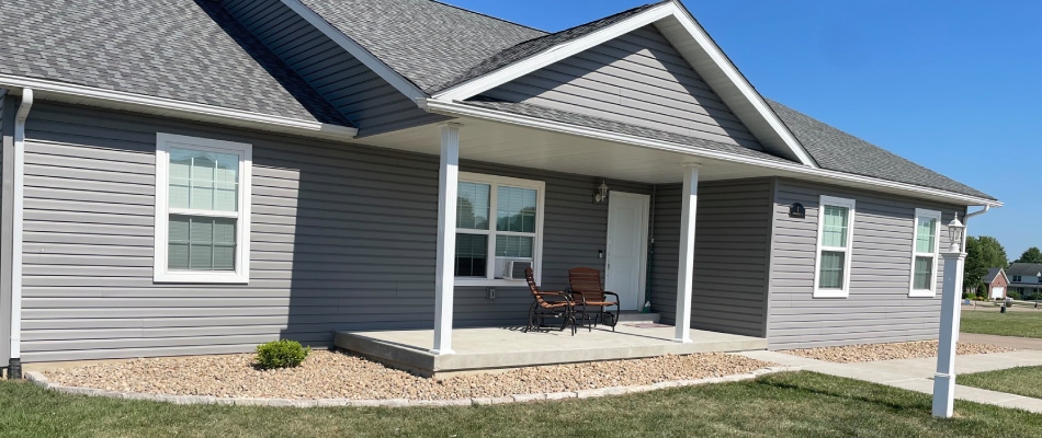 Front yard with landscape bed installed with river rock in Jerseyville, IL.