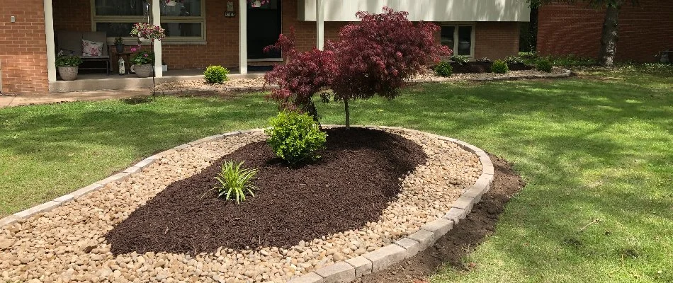 Mulch in landscape bed surrounded by rock on a property in Edwardsville, IL.