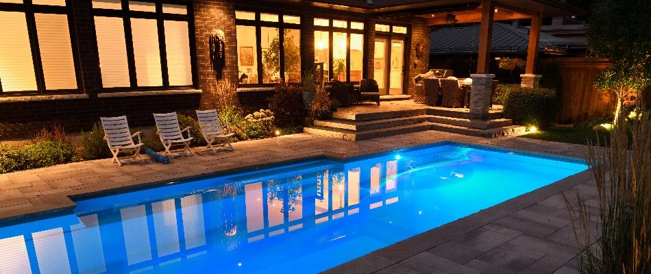 Patio area with lighting and a pool on a property in Edwardsville, IL.
