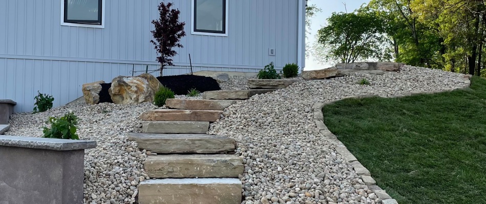 River rocks and plants installed by outdoor steps project installation in Greenville, IL.