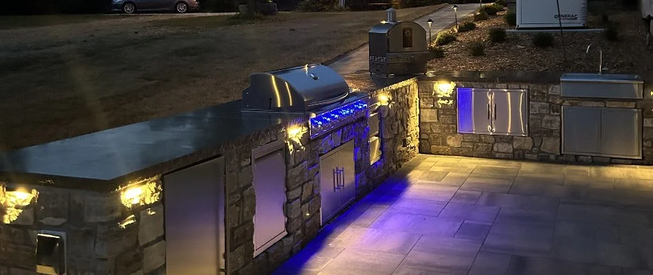 A stone outdoor kitchen in Godfrey, IL, with stainless steel appliances.