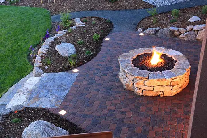 Custom stone fire pit and patio behind a Bethalto, IL home.